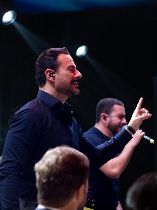 Gui e Léo cantando no palco de uma festa